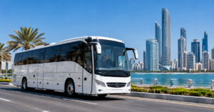 Bus rental Abu Dhabi – luxury white coach bus on a waterfront road with city skyline.